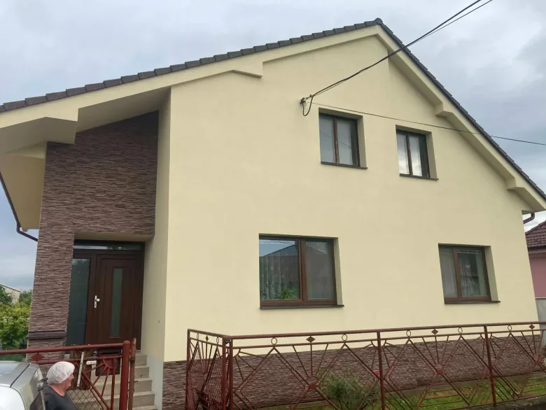 Svetlá fasáda rodinného domu s kontrastným dekoratívnym obkladom vstupu v Čachticiach – fotografia 5 z 6